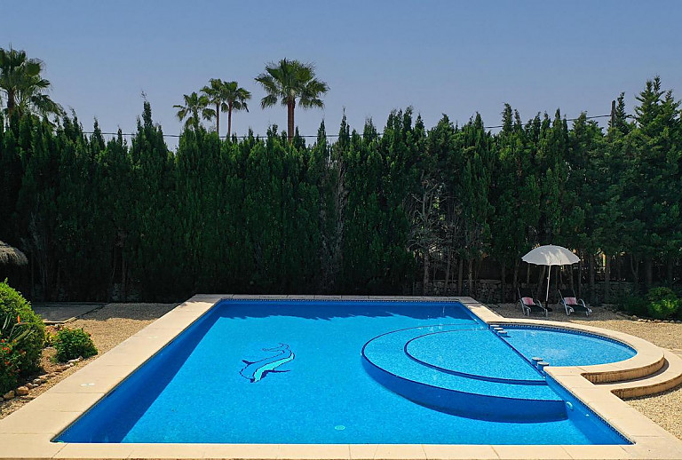 Poolterrasse mit Sonnenliegen und Sonnenschirm