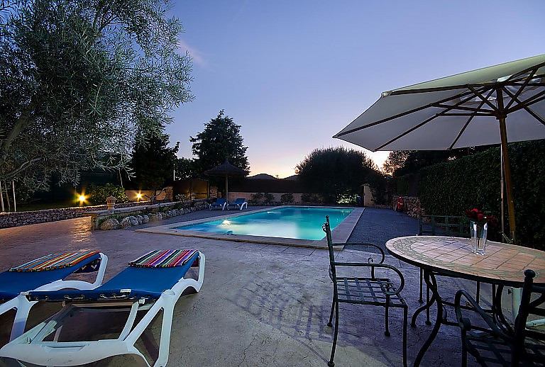 Gartentisch Stühle Poolbeleuchtung Sonnenliegen Abendhimmel