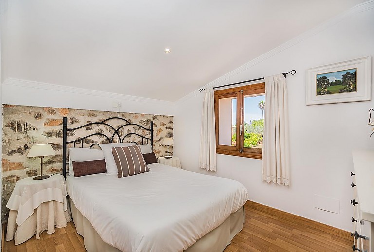 Schlafzimmer Betten Sessel Kommode Steinwand 