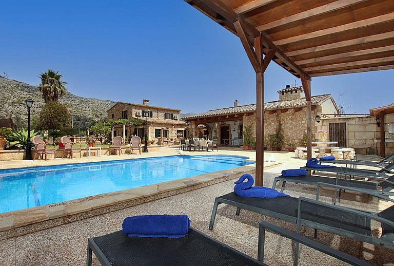 Poolbereich Tisch Stuehle Sonnenliegen Rutsche Terrasse