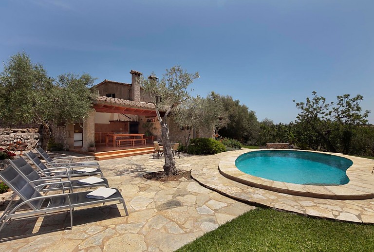 Pool Rasen Sonnenliegen Olivenbaum Aussenkueche Grill Sitzbaenke Tisch