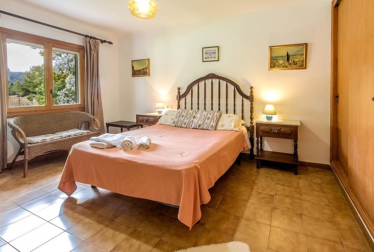 Doppelbett mit Fenster im Schlafzimmer