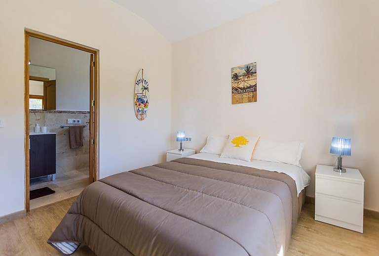 Schlafzimmer mit Doppelbett und integriertem Bad