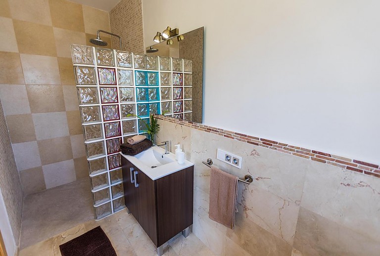 Dusche im Badezimmer mit Waschbecken und Spiegel