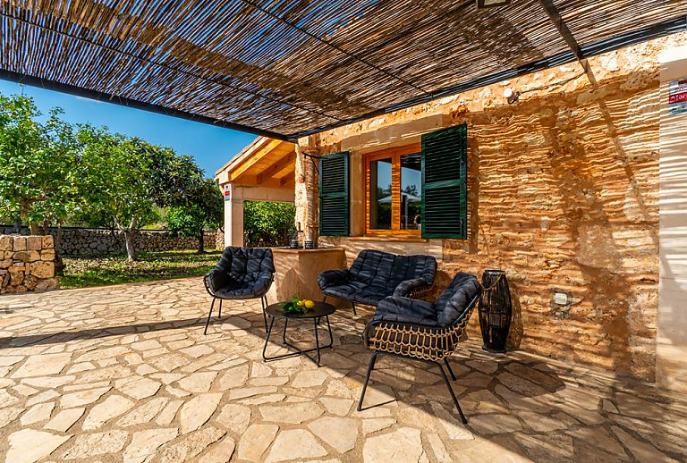 Terrasse mit Blick auf den Pool und Sonnenliegen