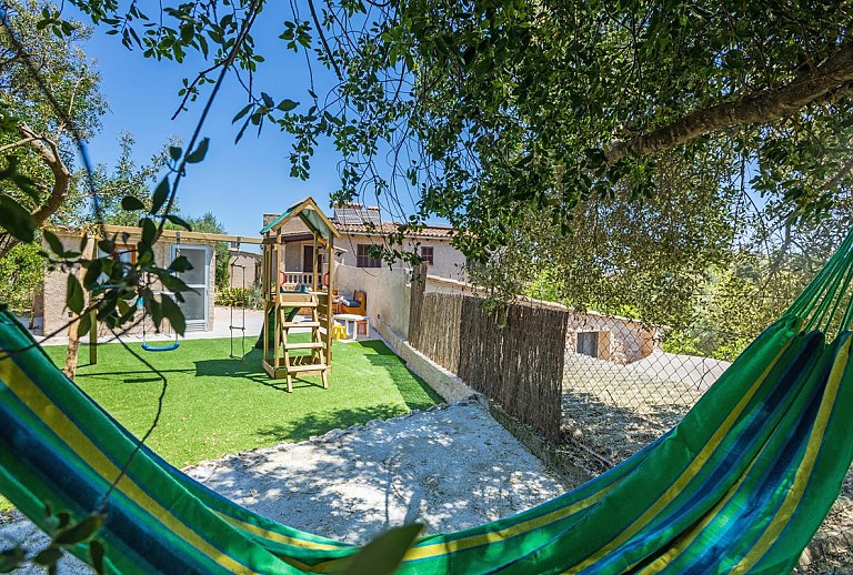 Sitzecke am Spielplatz mit Bäumen und Hängematte