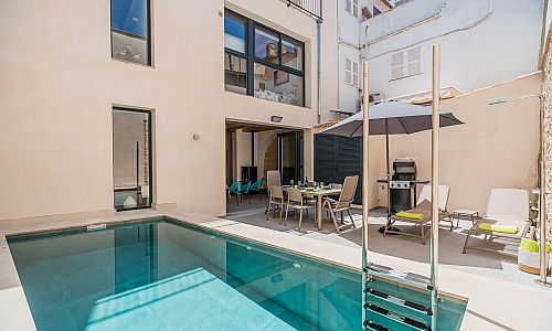 Pool im Hof des Ferienhauses mit Sonnenliegen und Sonnenschirm