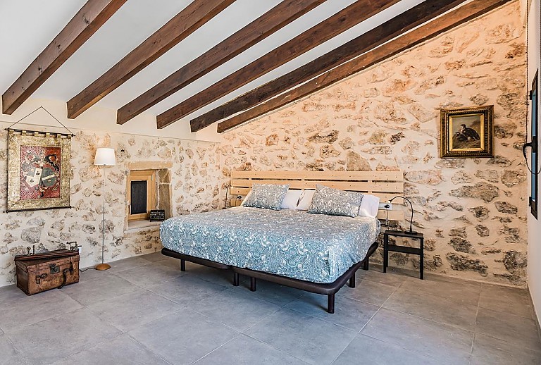 Schlafzimmer mit Doppelbett Natursteinwand und Klimaanlage