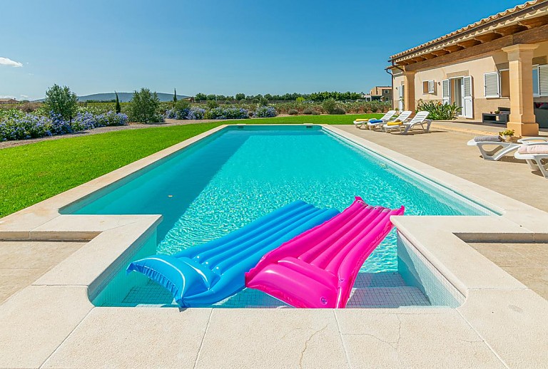 Luftmatrazen im Pool vor der Finca mit Rasenfläche