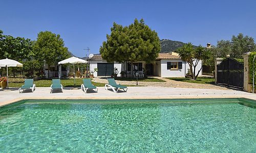 Poolbereich vor der Finca mit Sonnenliegen und Sonnenschirm