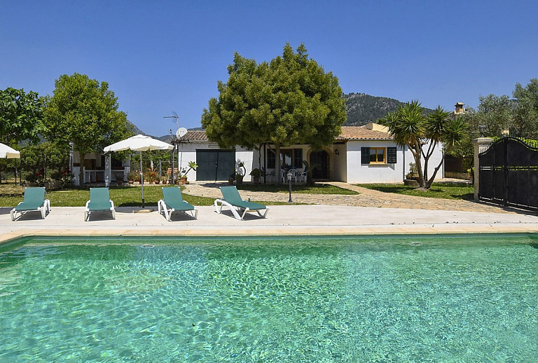 Poolbereich vor der Finca mit Sonnenliegen und Sonnenschirm