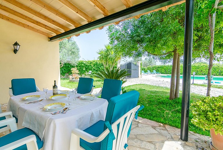 Terrasse mit Vordach und Esstisch im Schatten