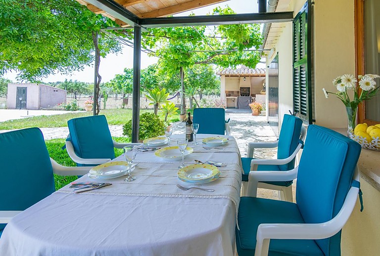 Terrasse mit Vordach und Esstisch im Schatten