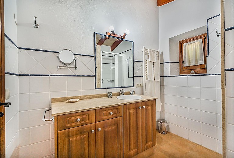 Badezimmer mit Fenster Waschbecken und Spiegel