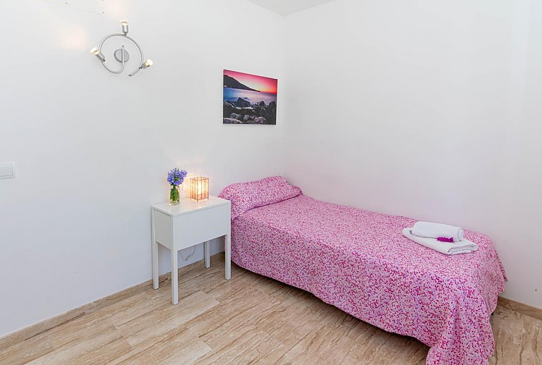 Schlafzimmer mit Einzelbett und Wandbild