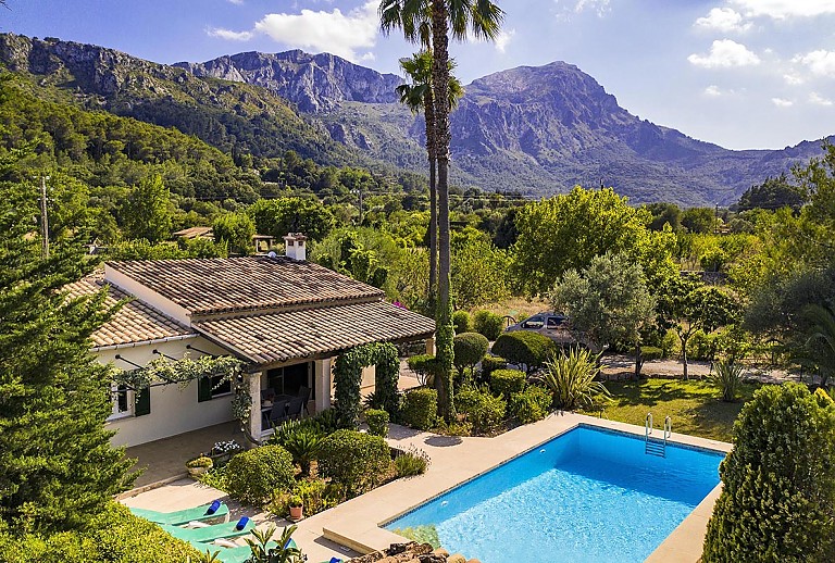 Poolbreich vor der Finca mit Sonnenliegen Pflanzen und Bäumen