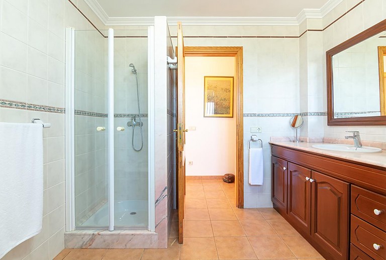 Dusche im Badezimmer mit Spiegel und Waschbecken
