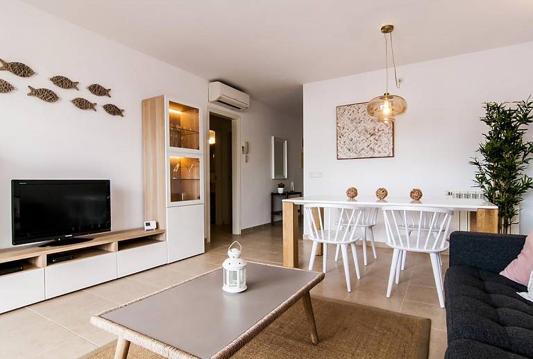 Wohnzimmer mit Fernseher und Esstisch