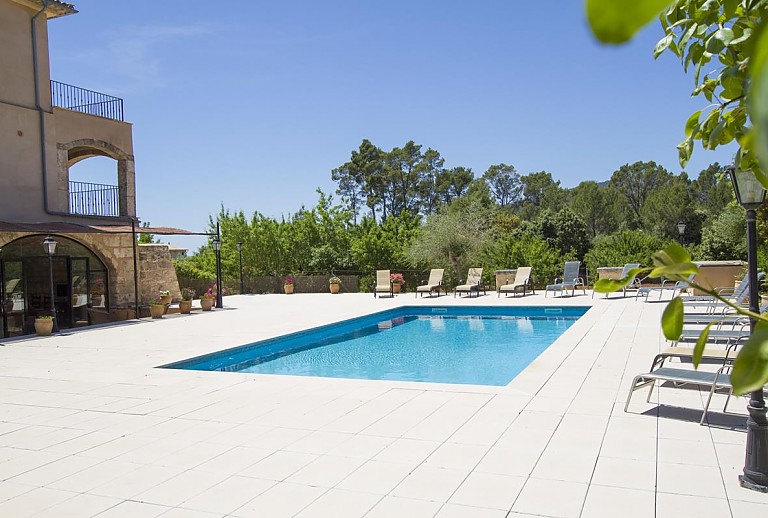 Außenbereich mit Pool Rasen und Bäumen vor der Finca