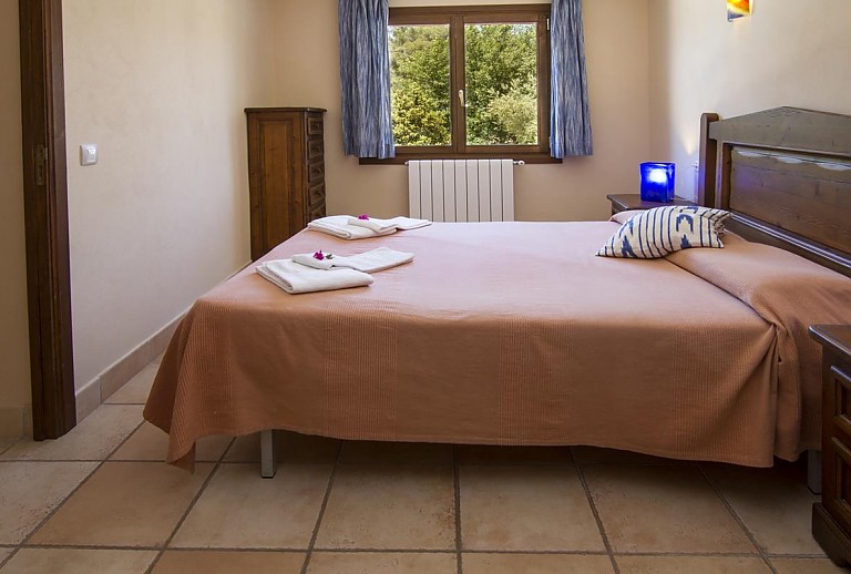 Schlafzimmer mit Doppelbett und Fenster