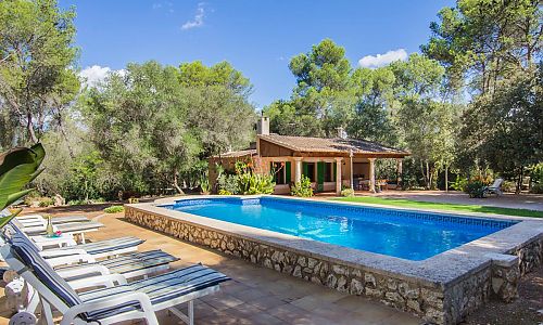 Außenbereich vor der Finca mit Pool Sonnenliege und Bäumen