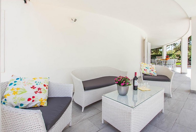 Terrasse mit Gartenmöbeln unterm Vordach