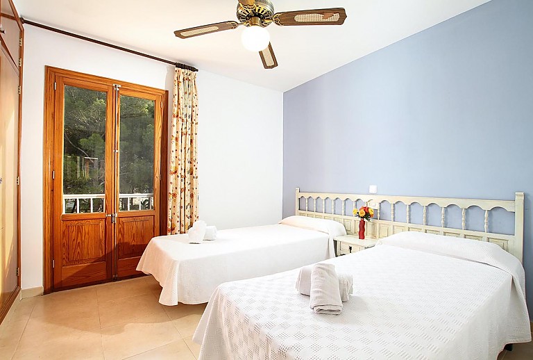 Schlafzimmer mit Einzelbetten und Zugang zur Terrasse