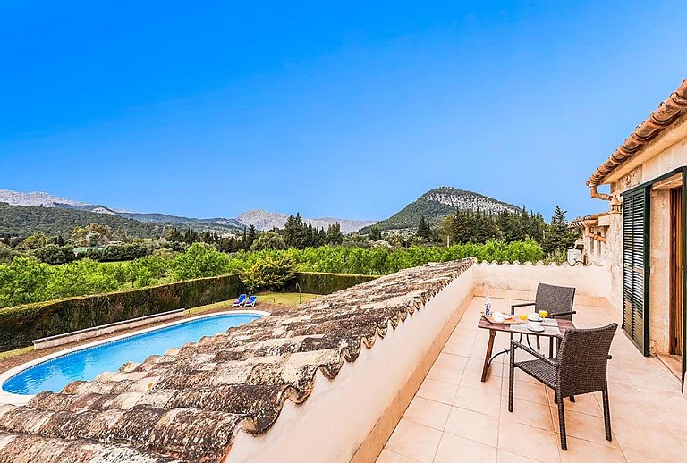 Terrasse mit Gartenmöbeln und Blick auf den Pool