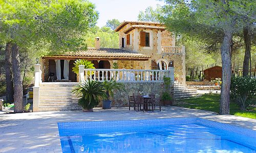 Pool mit Sonnenliegen und Bäumen vor der Finca