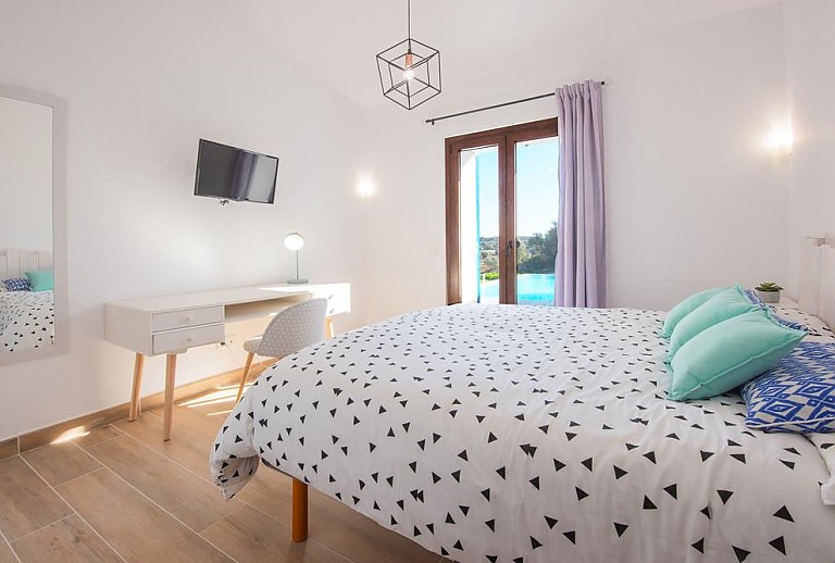 Schlafzimmer mit Doppelbett und Schreibtisch