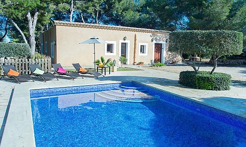 Pool vor der Finca mit Sonnenliegen und Bäumen