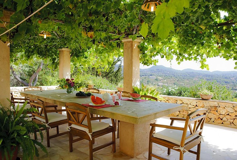 Bewachsene Terrasse mit Esstisch und Weitblick