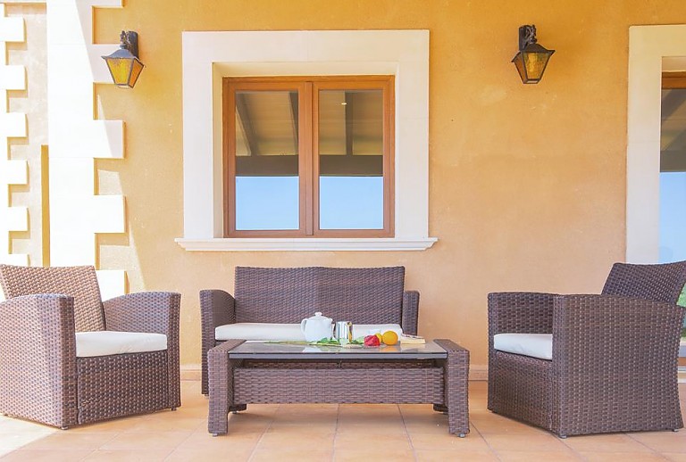 Terrasse mit Vordach und Sitzmöbeln