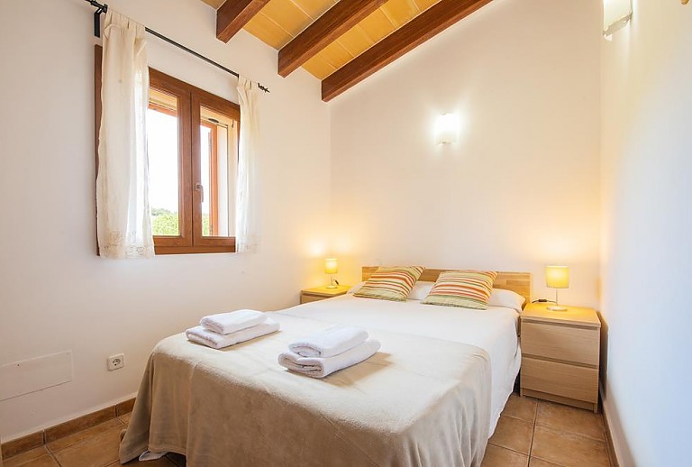 Schlafzimmer mit Doppelbett und Fenster