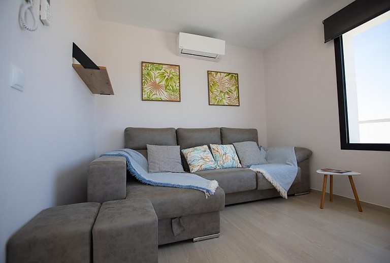 Wohnzimmer mit Couch und Klimaanlage