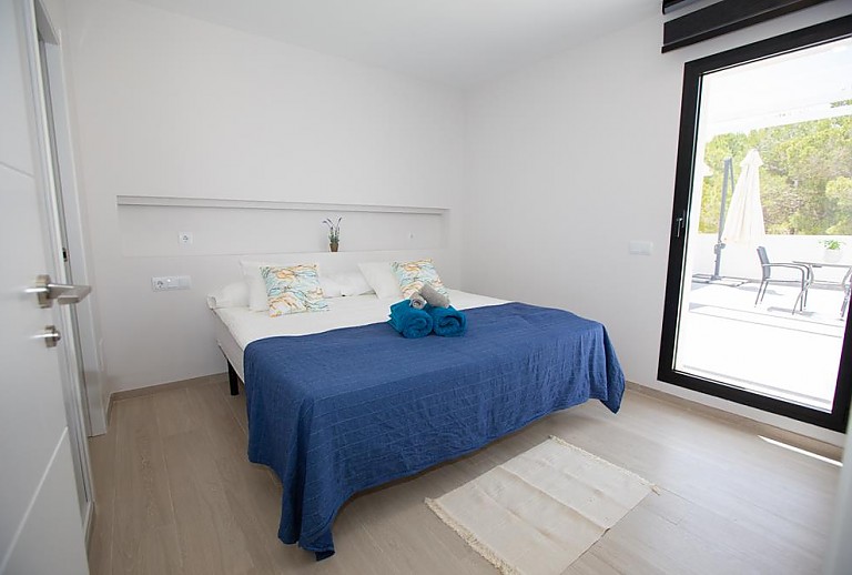 Schlafzimmer mit Doppelbett und Zugang zur Terrasse