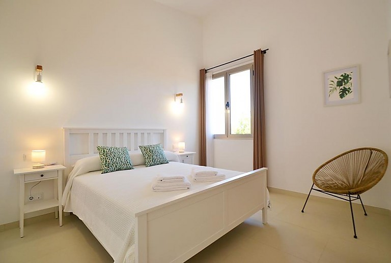 Schlafzimmer mit Doppelbett und Nachttisch