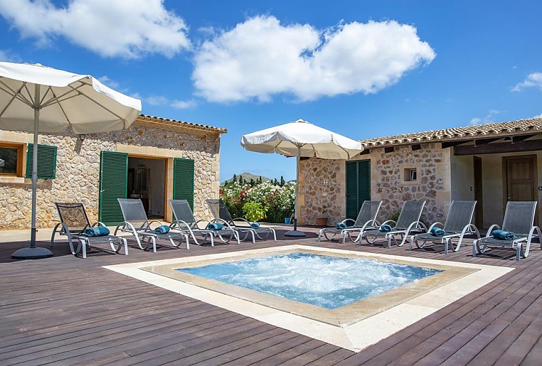 Poolbereich mit Poolliegen vor der Finca
