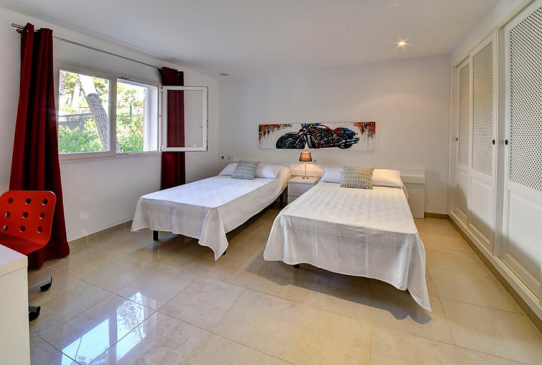Schlafzimmer mit Einzelbetten und Wandbild