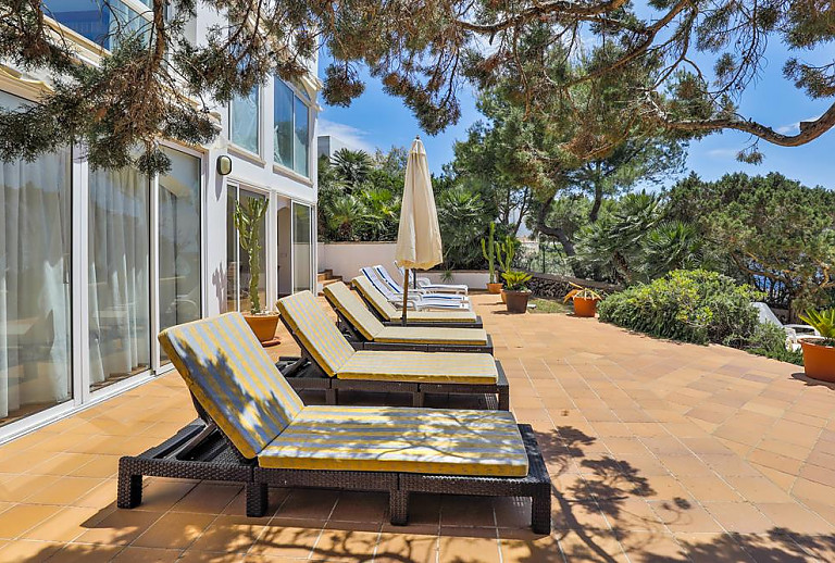 Sonnenschirm und Poolliegen auf der Terrasse