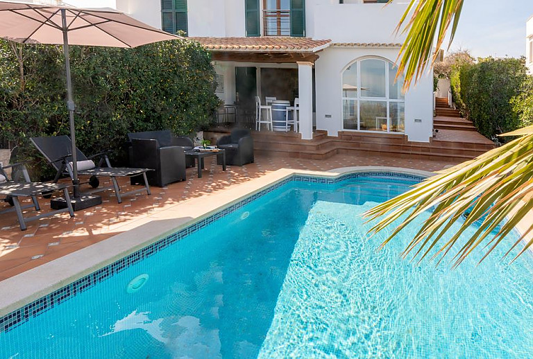 Ferienhaus mit Pool Hecke und Sonnenschirm
