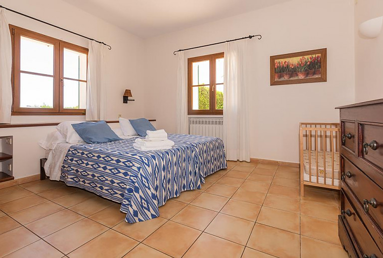 Schlafzimmer mit Doppelbett und Babybett