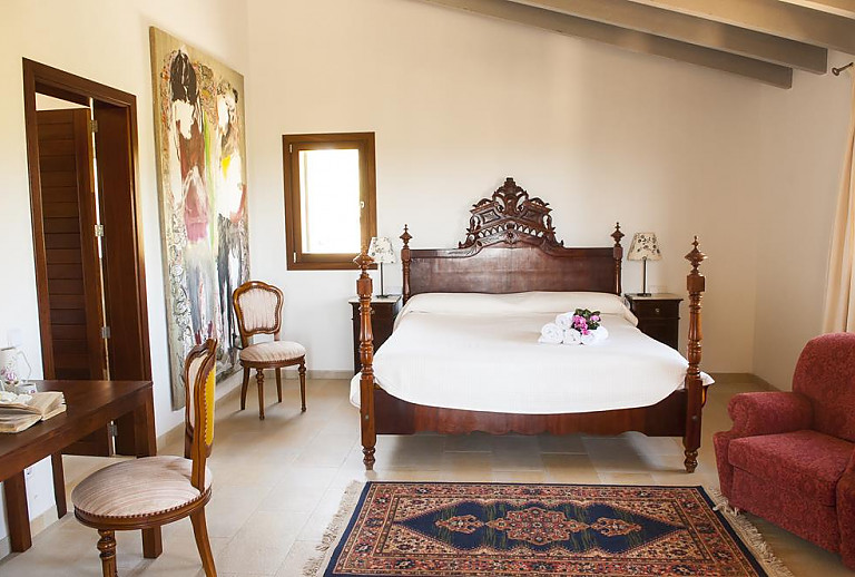 Schlafzimmer mit Doppelbett und Sessel
