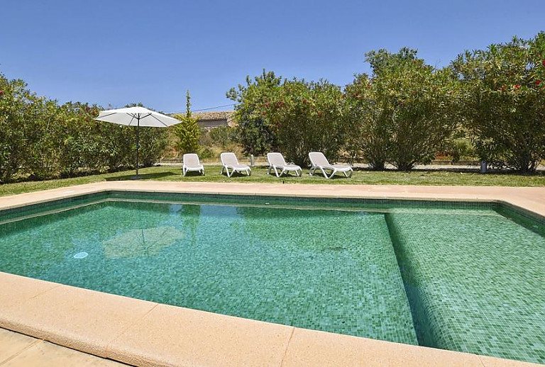 Pool mit Sonnenliegen vor der Finca