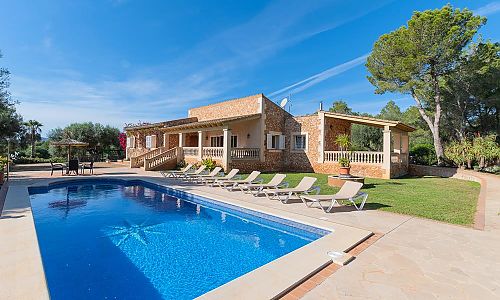 Pool mit Sonnenliegen vor dem Ferienhaus