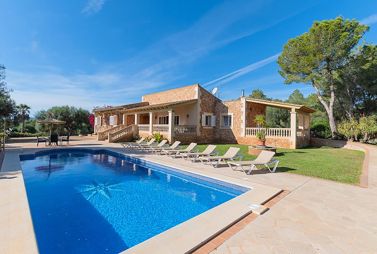 Pool mit Sonnenliegen vor dem Ferienhaus