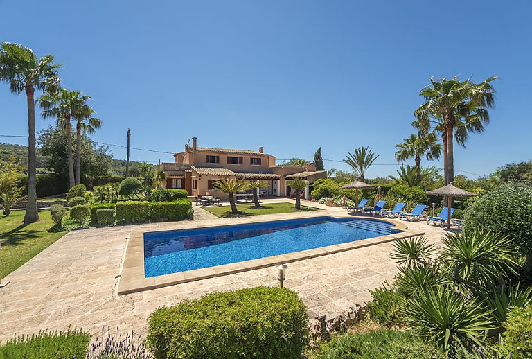 Pool mit Sonnenliegen vor dem Ferienhaus