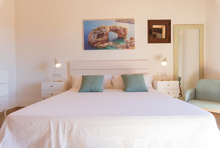 Schlafzimmer mit Doppelbett und Sessel
