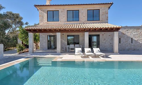 Pool mit Sonnenliegen vor dem Ferienhaus