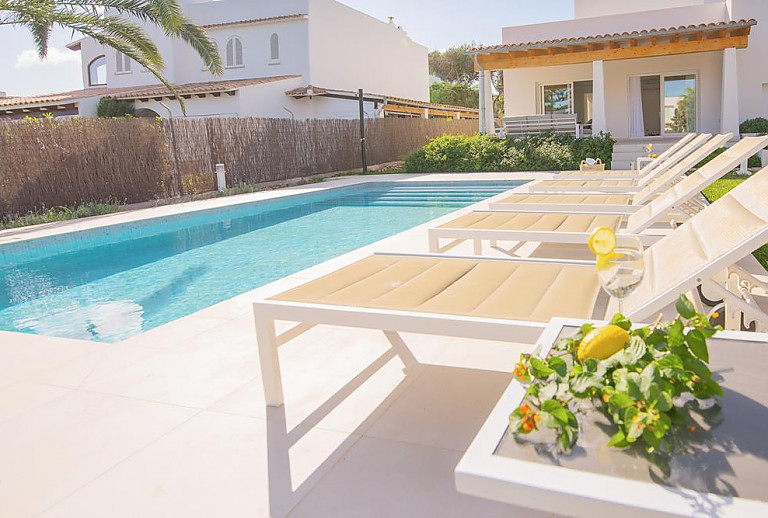 Sonnenliegen am Pool vor dem Ferienhaus